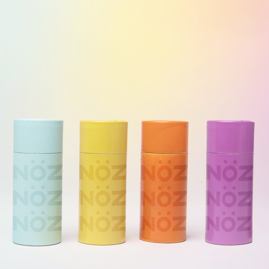 Front view of Nöz sunscreen tubes in shades blue, yellow, orange, and purple. 