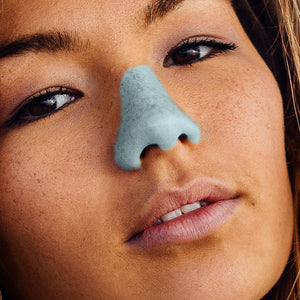 Woman wearing Nöz suncreen in shade blue.